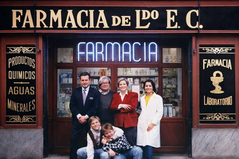 Феномен сериала «Дежурная аптека» (Farmacia de Guardia) и его значение для испанского телевидения Семья и сотрудники стоят у входа старинной аптеки с неоновой вывеской «FARMACIA», фасад с золотыми буквами и витриной с лекарственными товарами