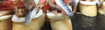 Тапас с анчоусами, яйцом и перцем на кусочках багета на гастрономическом маршруте в Алтее