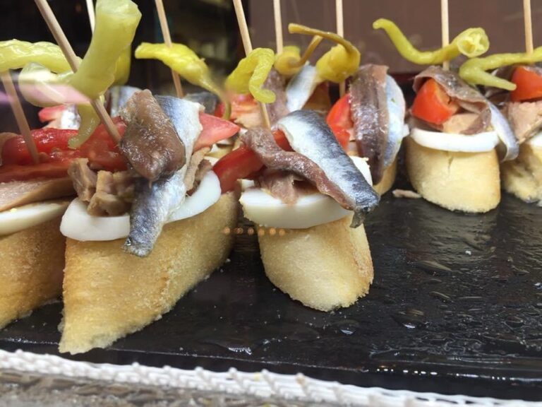 Тапас с анчоусами, яйцом и перцем на кусочках багета на гастрономическом маршруте в Алтее